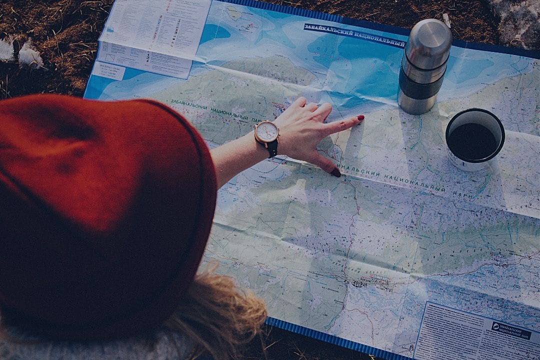 woman tracing route with her finger on a map