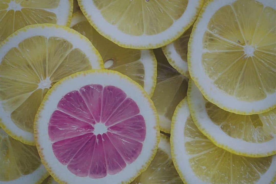 One pink lemon slice in a pile of yellow ones