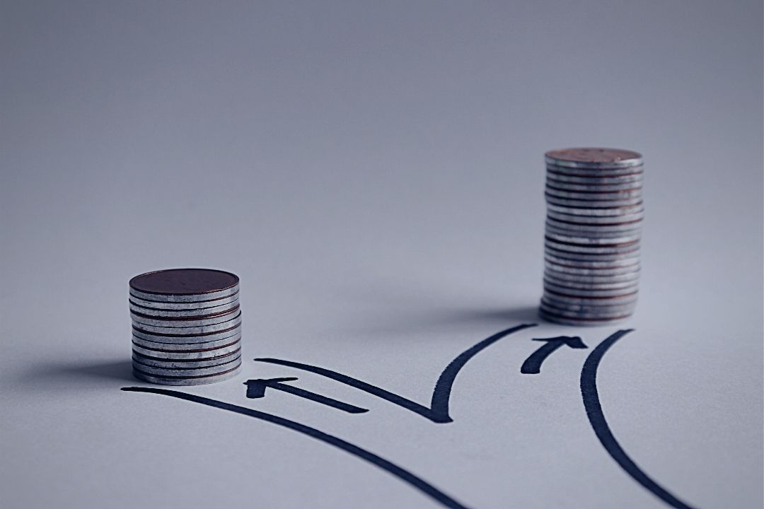 Stacks of coins sitting on a crossroads drawn on white surface