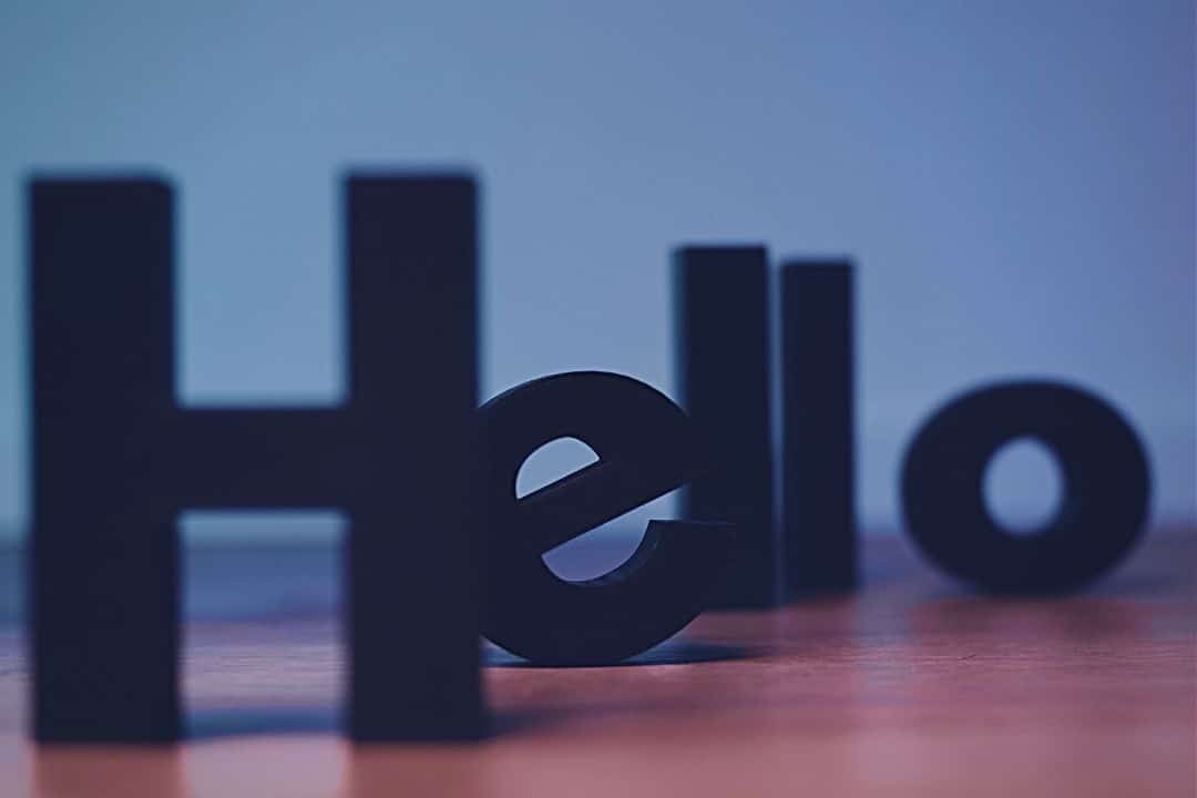Black wooden letters spelling out "Hello" standing on tabletop