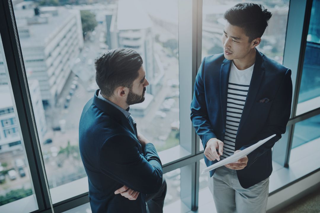 Businessmen talking over tablet