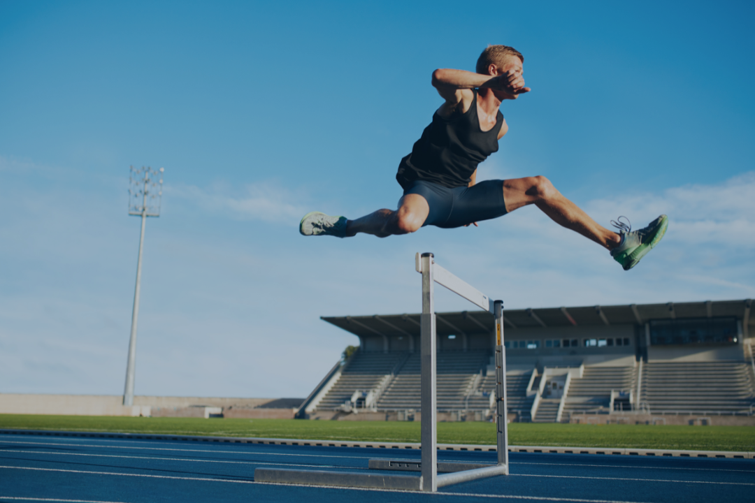 Athlete clearing hurdle